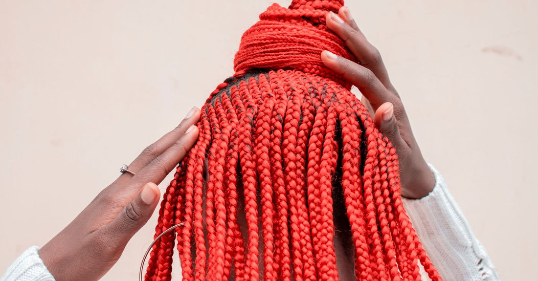 Woman with braids cradling her head with both hands after a tight install